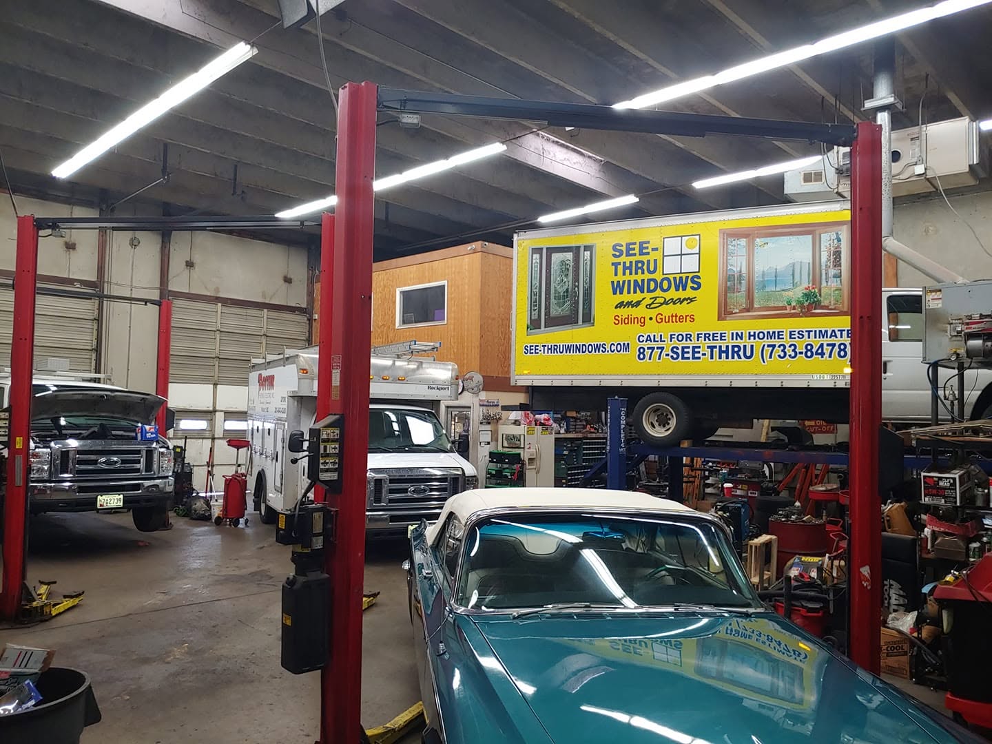Vehicles being repaired on lifts in our clean bay